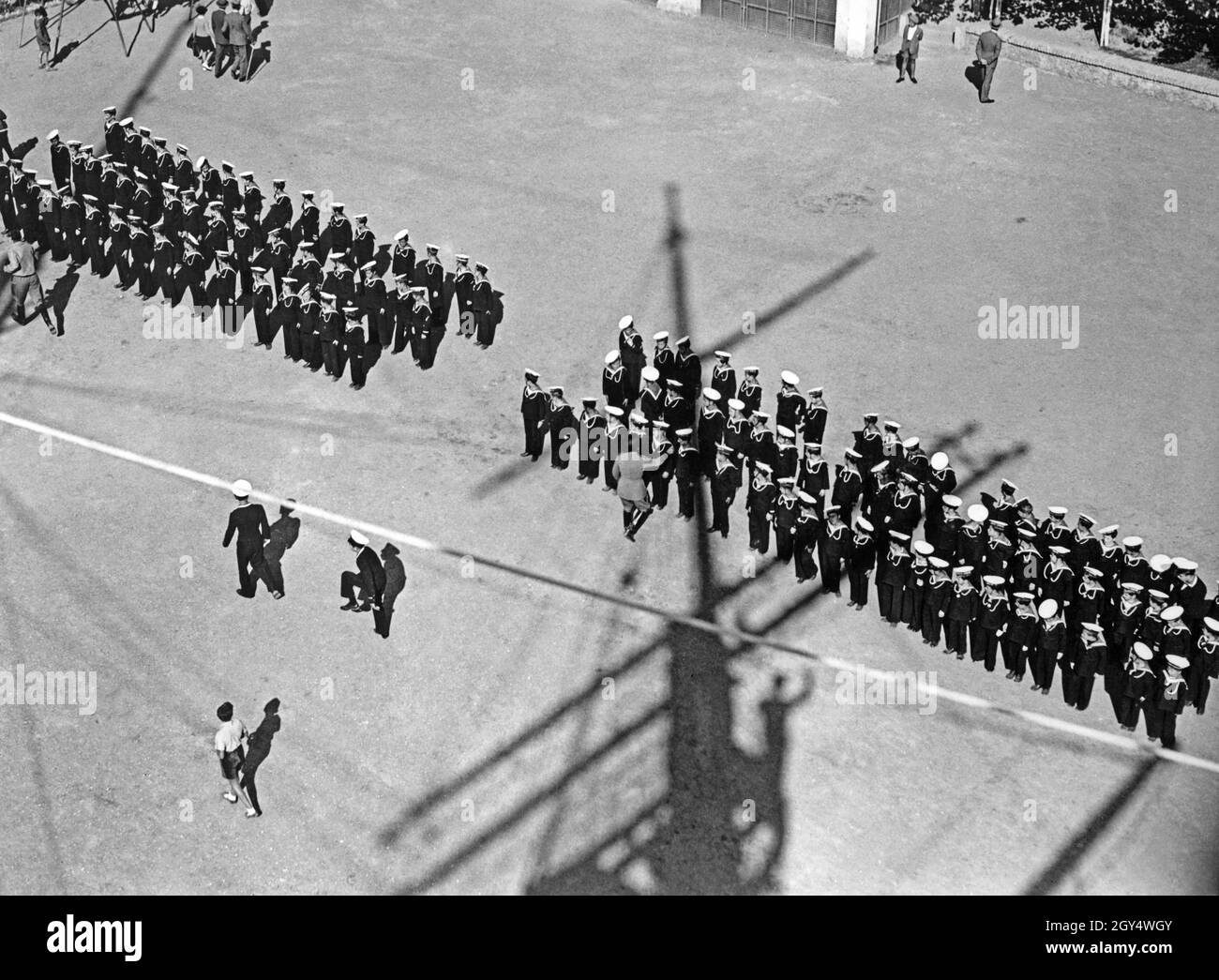 'Young students of the Naval School of the Italian youth organization Opera Nazionale Balilla (so-called Marinaretti) gathered in the courtyard of the Balilla House of the Marinaretti in Rome in 1933. The photograph was taken from the masthead of a sailing mast, which was permanently erected in the courtyard for practice purposes. The property was located on the right bank of the Tiber in the street Lungotevere Flaminio (today it houses the ''Circolo Ufficiali Marina Militare'', the officers' mess of the Italian Navy). [automated translation]' Stock Photo