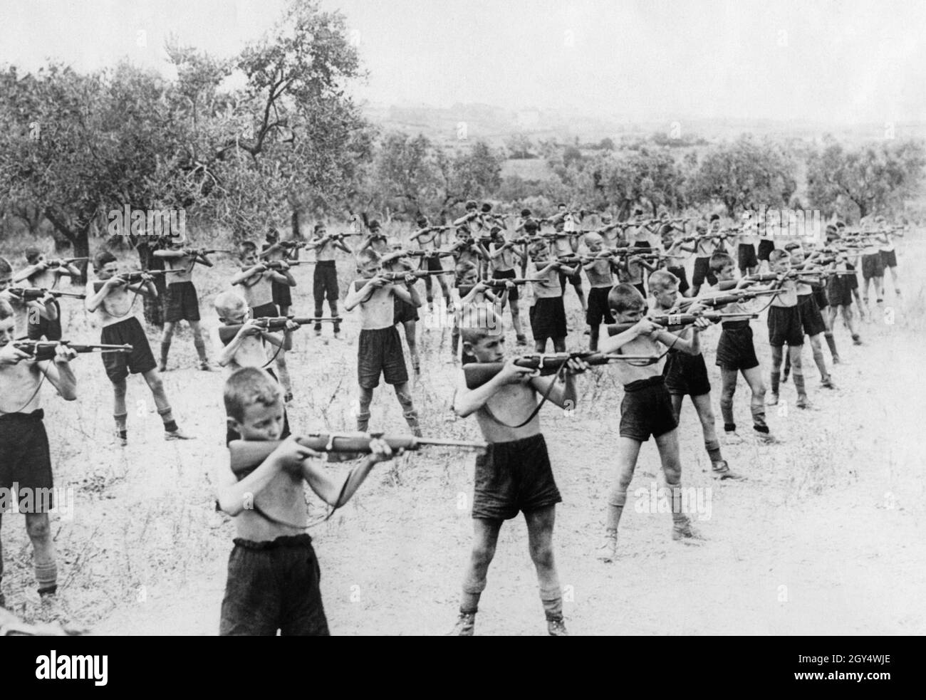 At a camp in the summer of 1934, boys belonging to the fascist youth organization Opera Nazionale Balilla practice using a rifle in target practice. The picture was taken on August 17 in Grottaferrata southeast of Rome, the site of the summer camp. In the Balilla, the young people were drilled in sports and military skills for their later entry into the army. [automated translation] Stock Photo