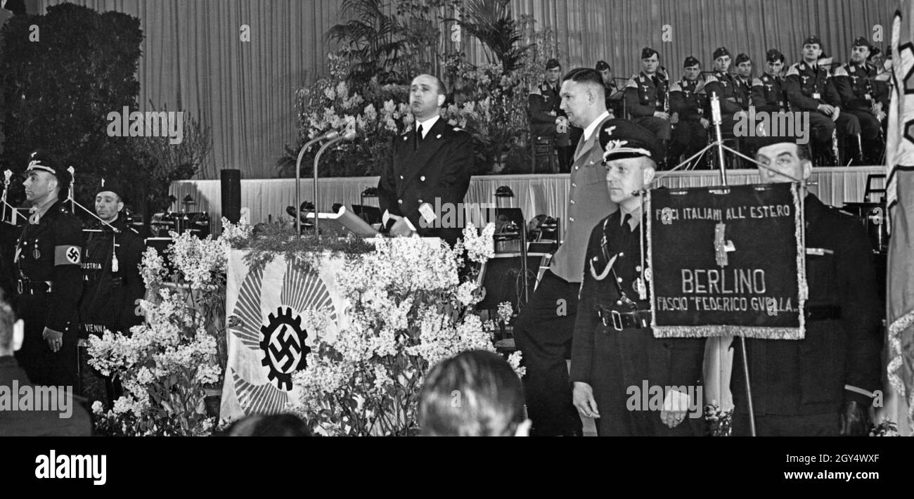 'On April 21, 1941, the Italian ''Festa del Lavoro'' (Labor Day), a rally was held at the Berlin Sportpalast. The picture shows the Italian ambassador's representative, envoy Giuseppe Cosmelli, speaking to Italian industrial workers employed in Berlin. In front of the lectern hangs the symbol of the Nazi organization ''Strength through Joy''. On the right is a standard of the Italian fascist organization in Berlin: ''Fasci italiani all'estero / Berlino / Fascio Federico Guella''. [automated translation]' Stock Photo