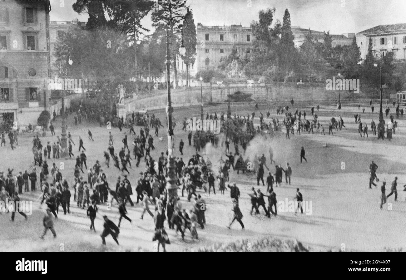 Clashes and riots broke out in Rome in 1924 on November 4, the day of the Victory Day celebrations. The picture shows a violent confrontation in the Piazza del Popolo. General Giuseppe Garibaldi the Younger was coming from the Porta del Popolo with some red shirts when a detachment of out-of-town fascists attacked them. In the centre of the picture is the smoke of fired pistols, whereupon the crowd fled. The Fontana del Nettuno can be seen in the background. Victory Day commemorated Italy's armistice with Austria-Hungary on 4 November 1918. [automated translation] Stock Photo