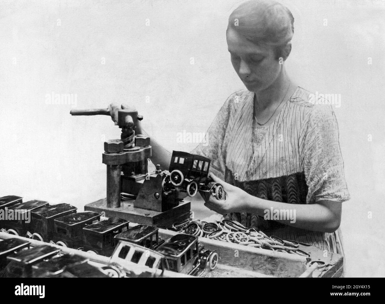 Toy industry in Germany A worker produces toy cars with a punch