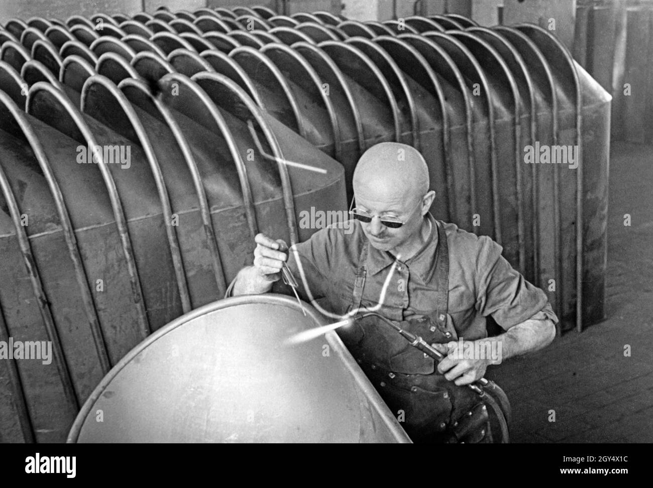 A worker soldering the rims of bathtubs at the KrauΓ factory in Neuwelt ...