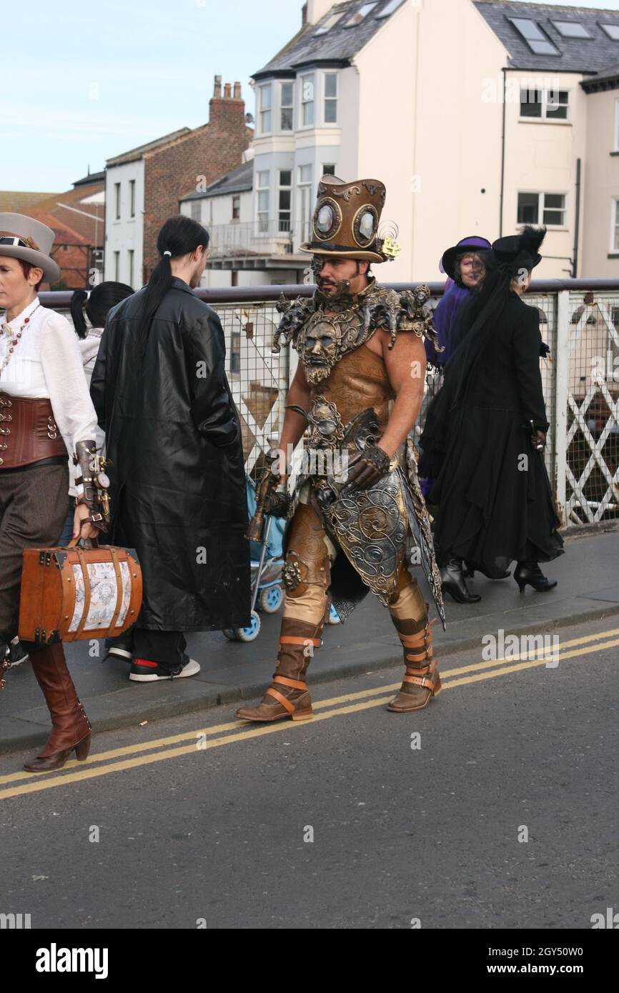 Gentleman dressed as outlandish steampunk character crossing bridge in Whitby during Goth Weekend Stock Photo