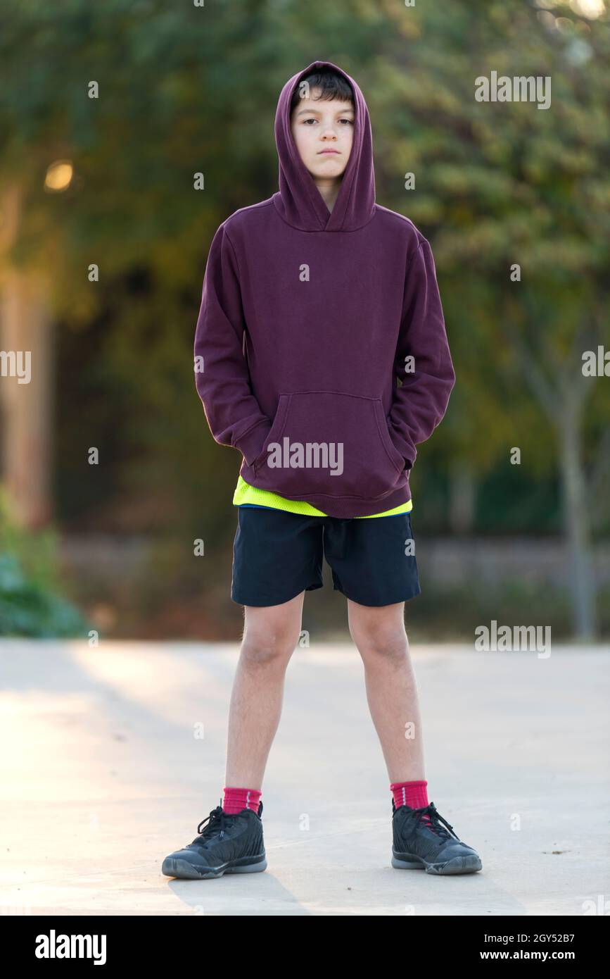 An Outdoor handsome boy portrait. Teen boy in hood over park nature  background Stock Photo - Alamy