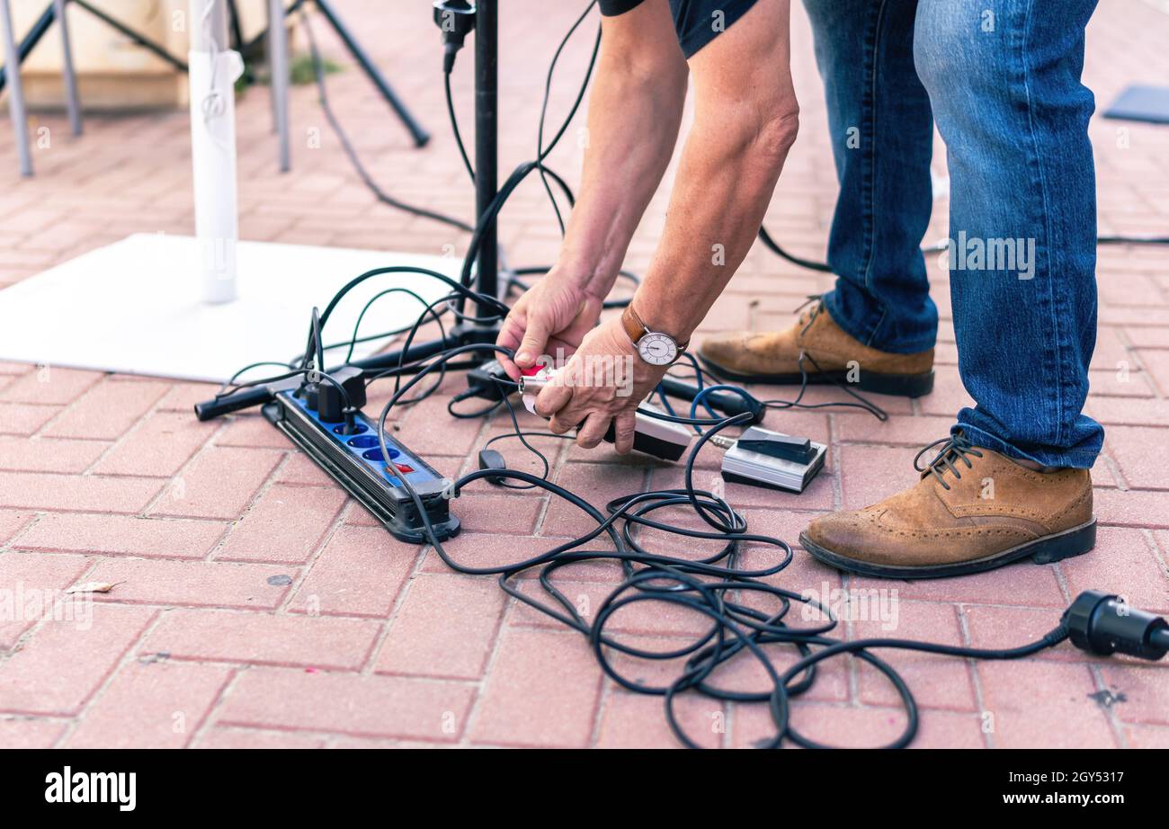 Sound technician picking up cables from the floor after a live concert Stock Photo Alamy