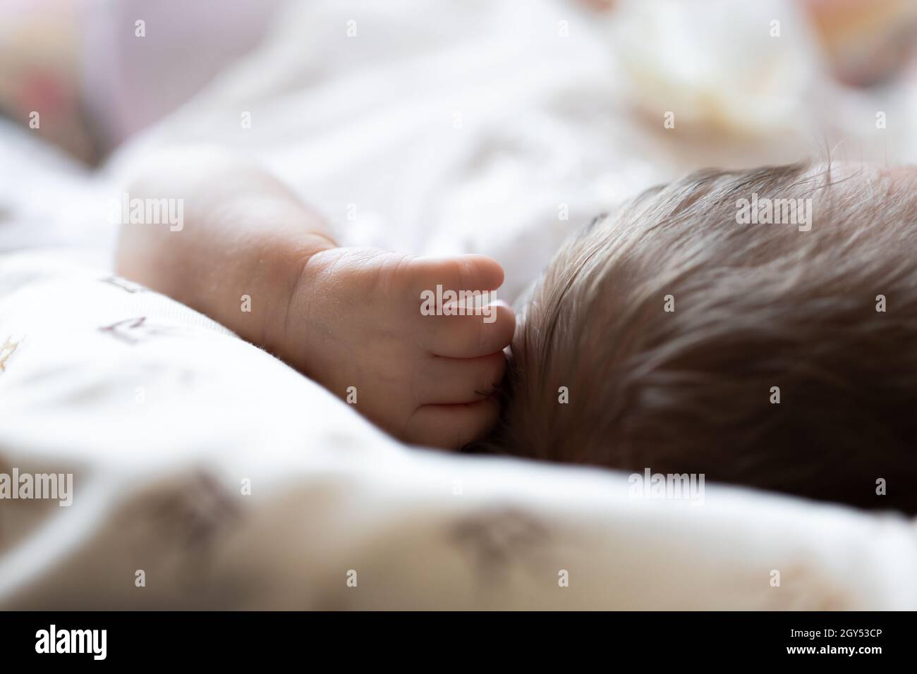 Hand and head of a baby sleeping in a crib Stock Photo Alamy