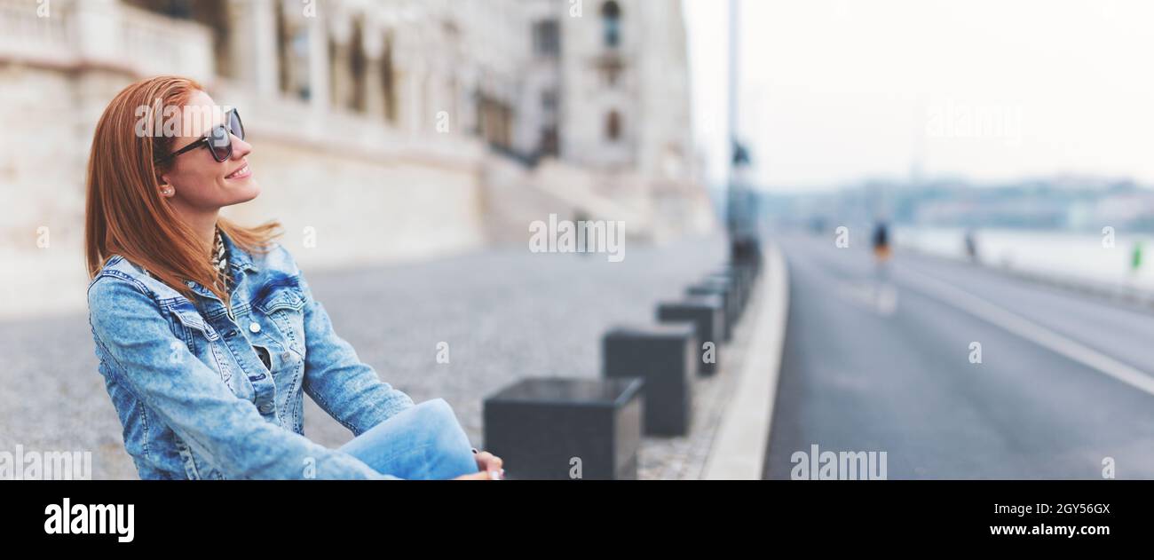 Young cheerful redhead hungarian woman relaxing at Parliament building, Budapest, Hungary Stock Photo