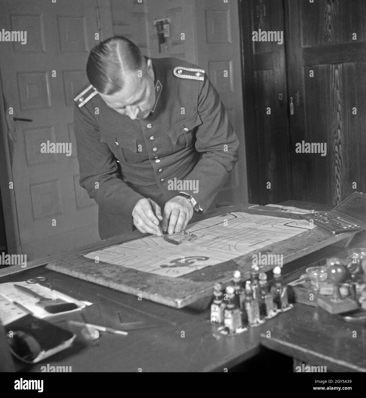 Ein Polizist des Verkehrsunfallkommandos erstellt einen Straßenplan, Deutschland 1930er Jahre. A policeman of the Verkehrsunfallkommando drawing a street map, Germany 1930s. Stock Photo