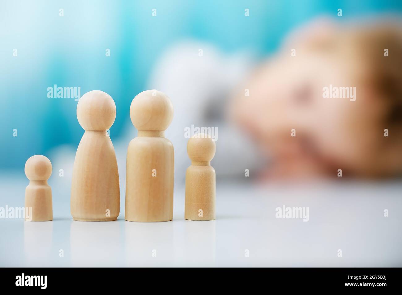 Wooden figures of the family on the blue background Stock Photo