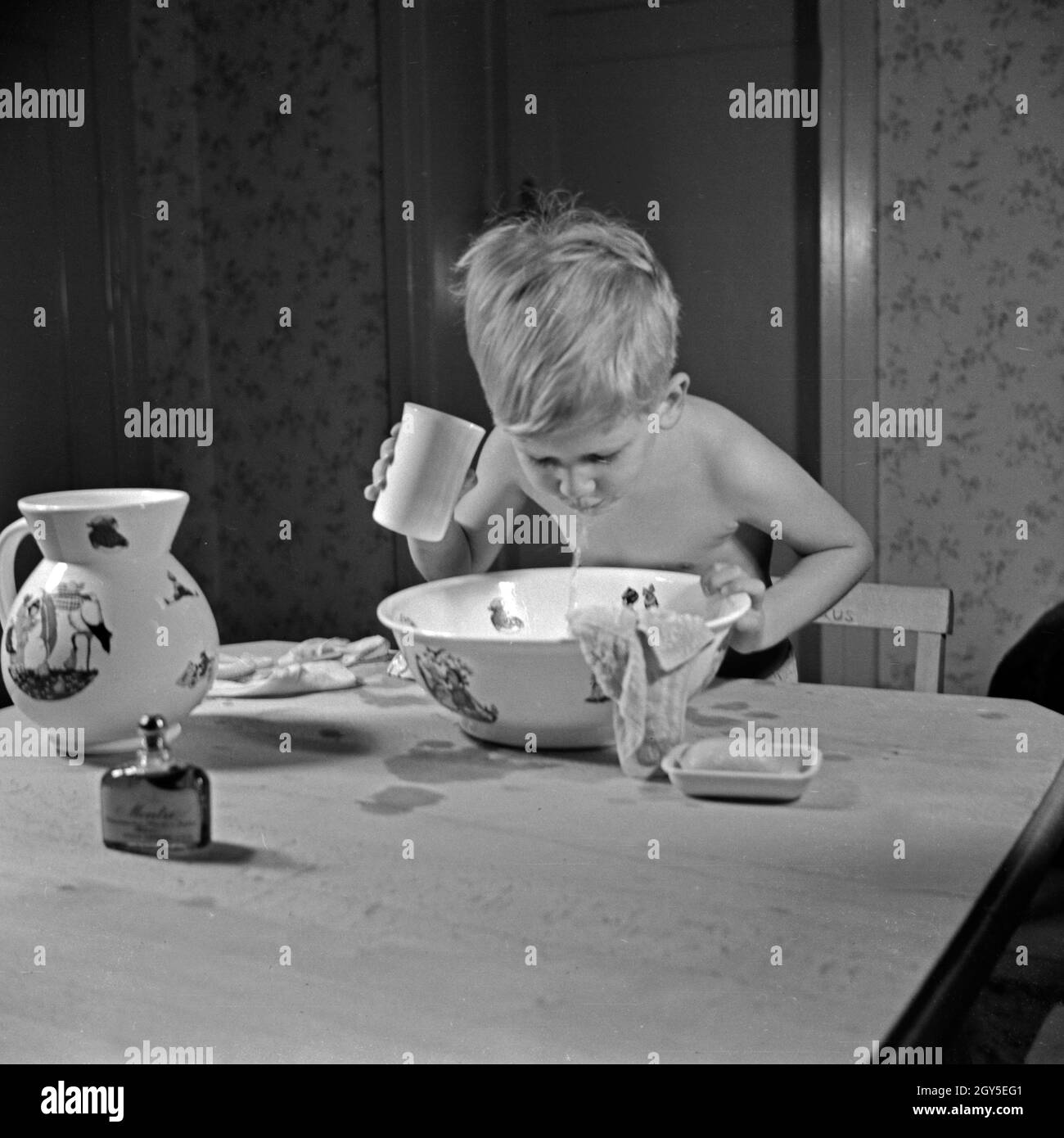 Ein kleiner Junge bei einer Mundspülung nach dem Zähneputzen, Deutschland 1930er Jahre. A little boy after brushing his teeth, Germany 1930s. Stock Photo