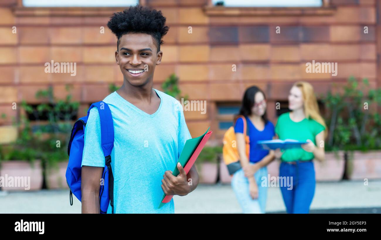 Young african american male student with group of international students outdoor in city Stock Photo