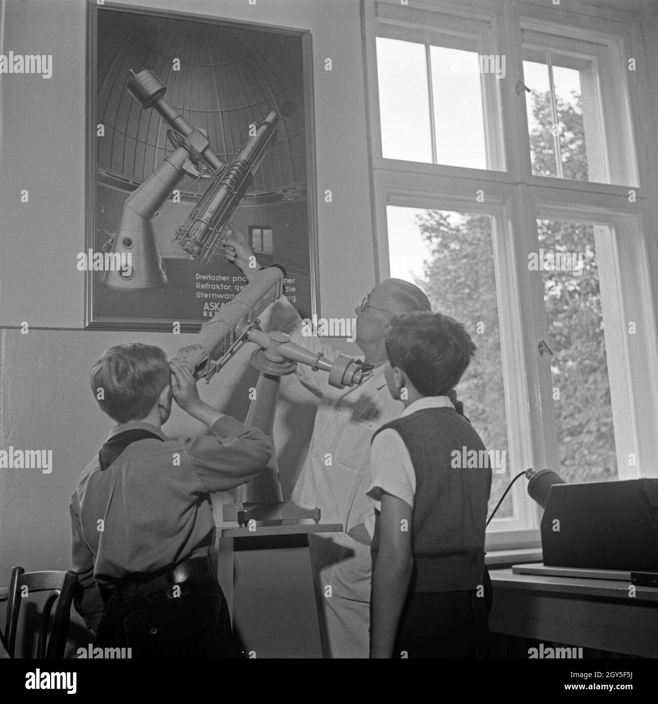 Ein Mitarbeiter erläutert an einem Modell die Funktionsweise eines Teleskops in der Sternwarte Berlin Treptow, Deutschland 1930er Jahre. A staff member explaining the function of a telescope at the Berlin Treptow, observatory, Germany 1930s. Stock Photo