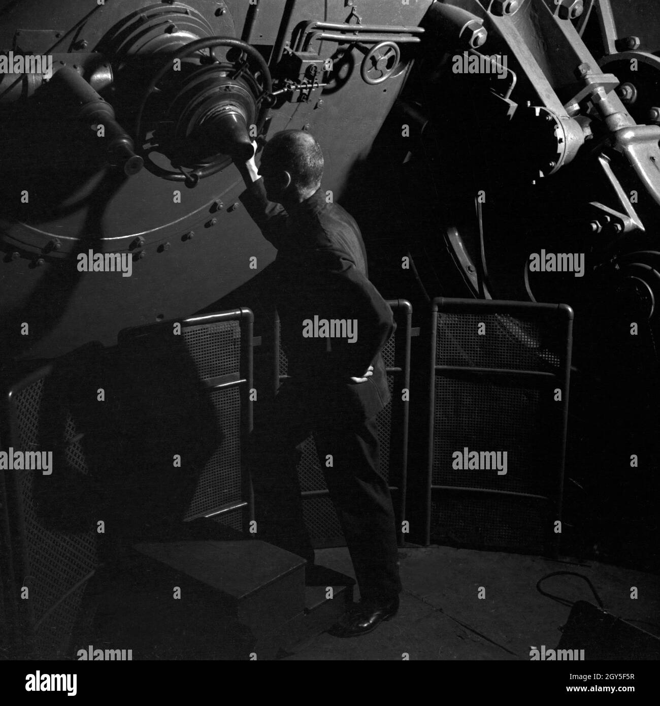 Ein Mitarbeiter erläutert am Teleskop auf dem Dach der Sternwarte Berlin Treptow, Deutschland 1930er Jahre. A staff member at the telescope on the roof of the Berlin Treptow observatory, Germany 1930s. Stock Photo