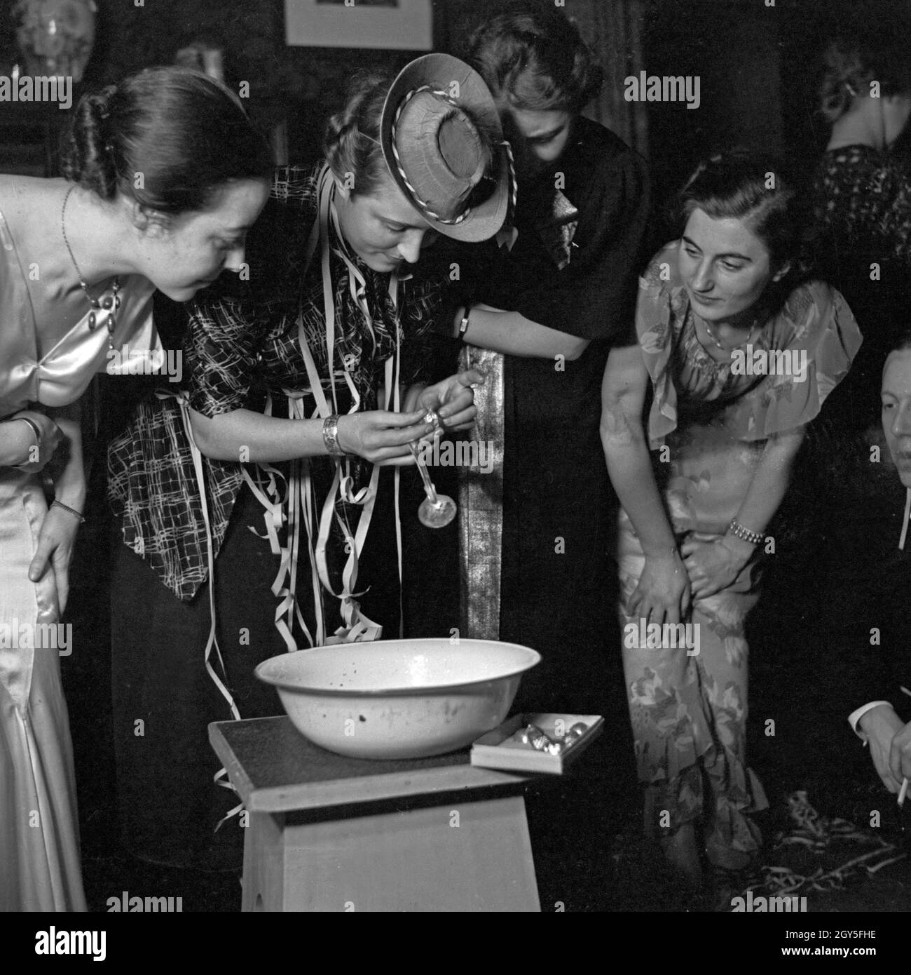 Fertigmachen zum Bleigießen auf einer Silvesterparty, Deutschland 1930er Jahre. Get ready for lead pouring at a new year's eve party, Germany 1930s. Stock Photo