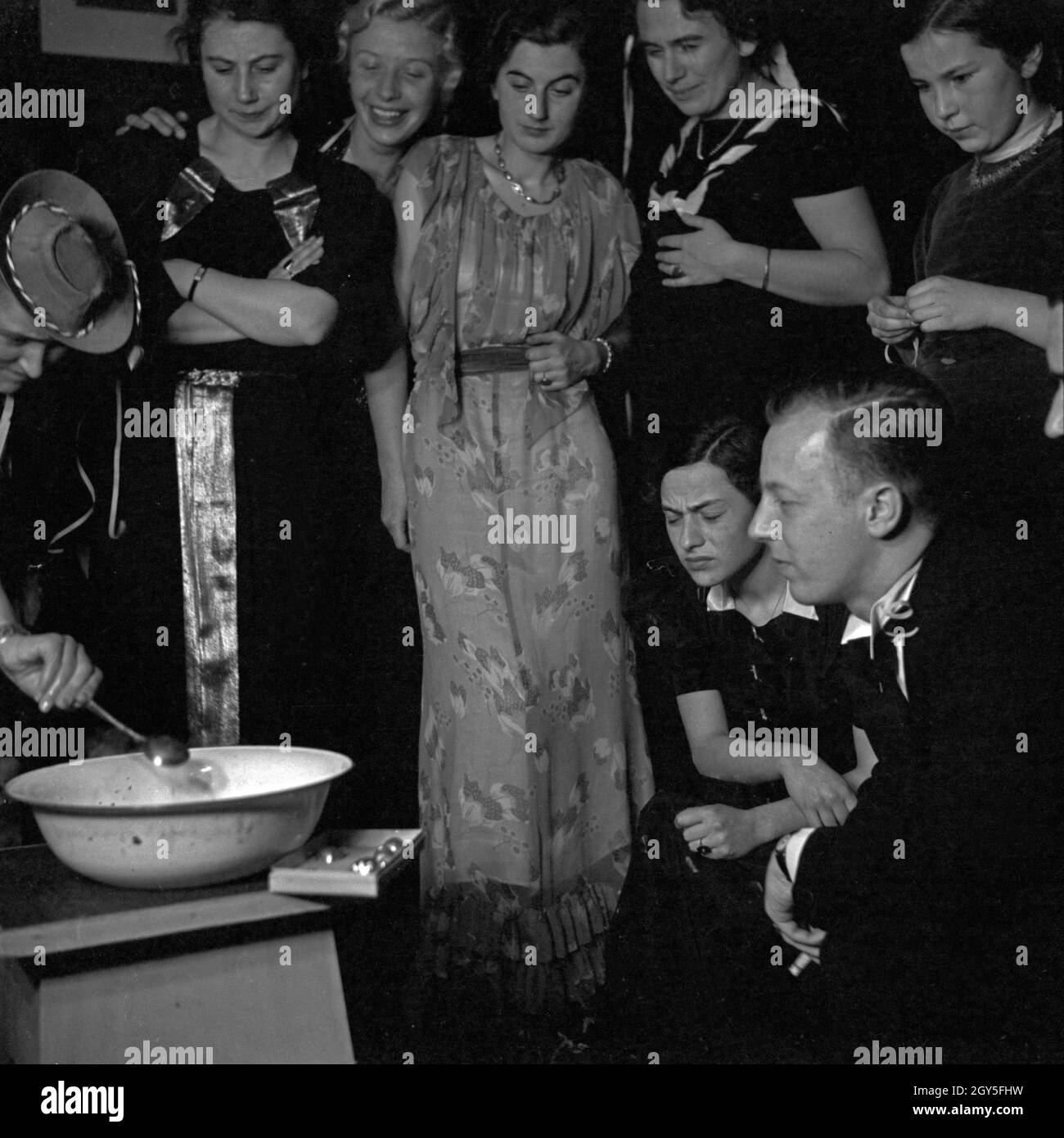 Fertigmachen zum Bleigießen auf einer Silvesterparty, Deutschland 1930er Jahre. Get ready for lead pouring at a new year's eve party, Germany 1930s. Stock Photo