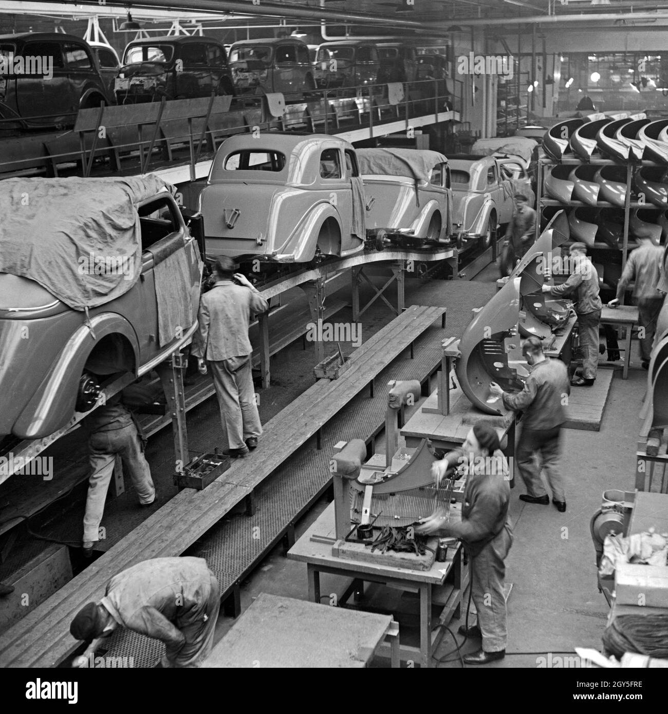 Arbeiter der Ford Werke in Köln Niehl am Fließband mit Karosserien, Deutschland 1930er Jahre. Workers at the conveyor belt of the Ford factory at Cologne, Germany 1930s. Stock Photo