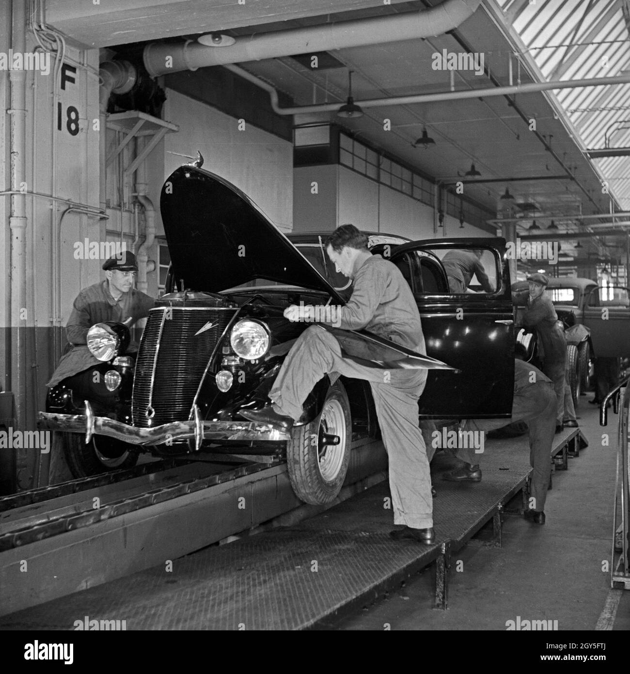 Ein Ford V8 läuft vom Band in den Ford Werken in Köln Niehl, Deutschland 1930er Jahre. A Ford V8 at its final work station at the Ford factory at Cologne, Germany 1930s. Stock Photo