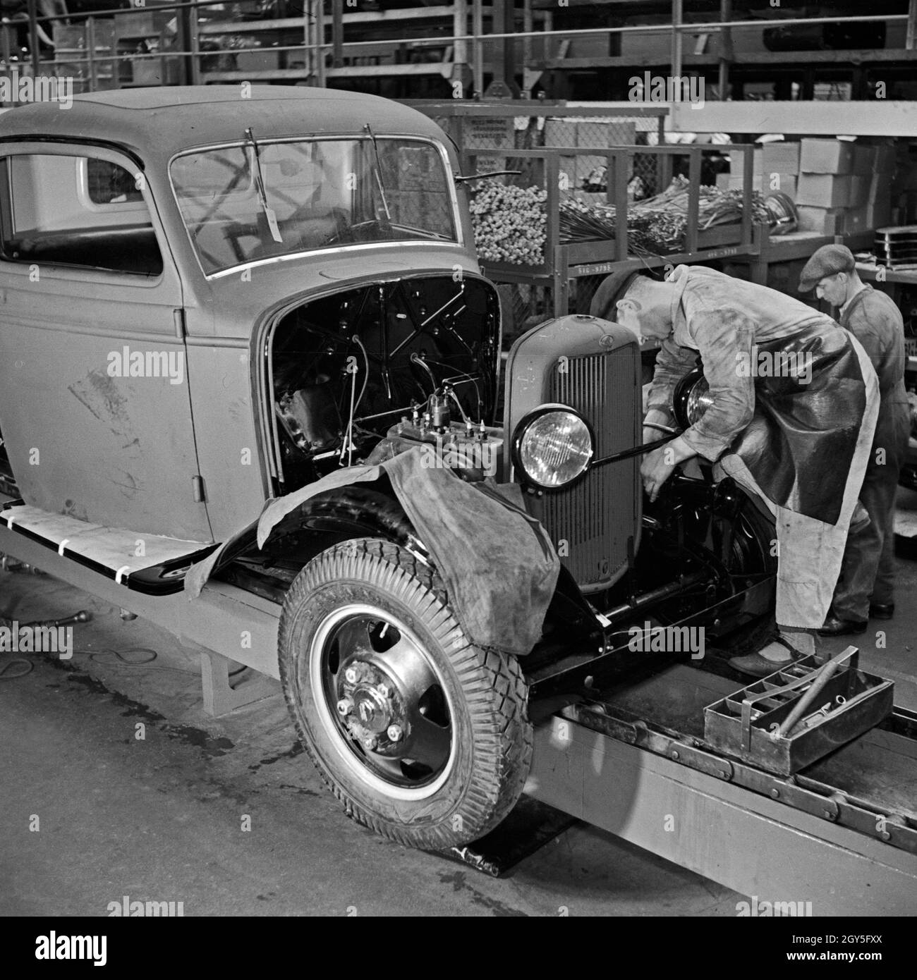 Arbeiter der Ford Werke in Köln Niehl bei der Reparatur an alten Karosserien, Deutschland 1930er Jahre. Workers repairing old chassis at the Ford factory at Cologne, Germany 1930s. Stock Photo