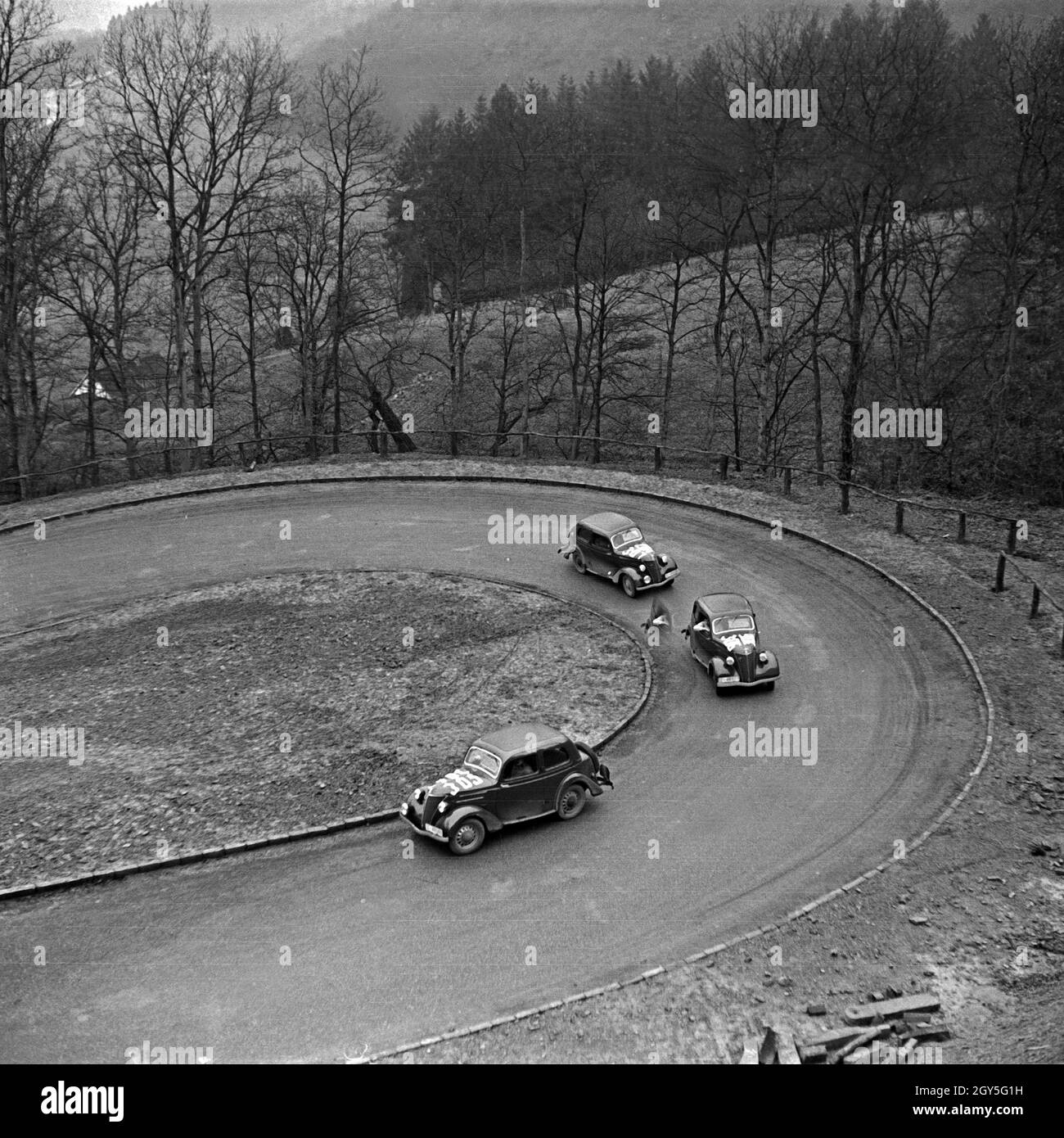 Drei Ford Eifel durchfahren eine Haarnadelkurve während einer Autorallye, Deutschland 1930er Jahre. Three Ford models Eifel driving through a hairpin bend at a car rallye, Germany 1930s. Stock Photo