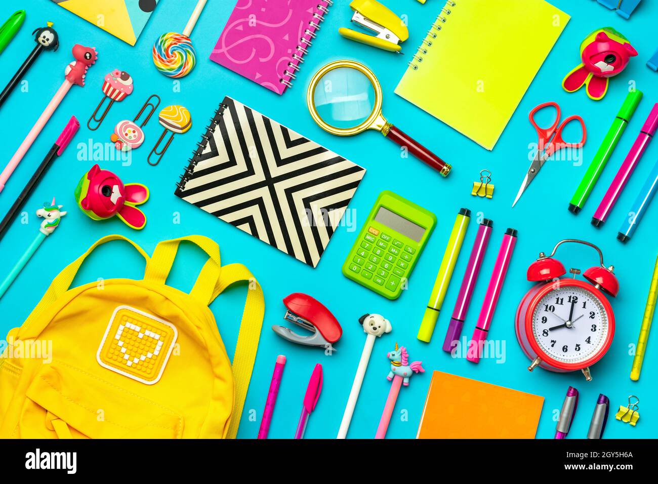 Frame from school and office supplies Paper clips, scissors, pens, felt-tip pens, sharpener, calculator, stapler isolated on blue background Flat lay Stock Photo