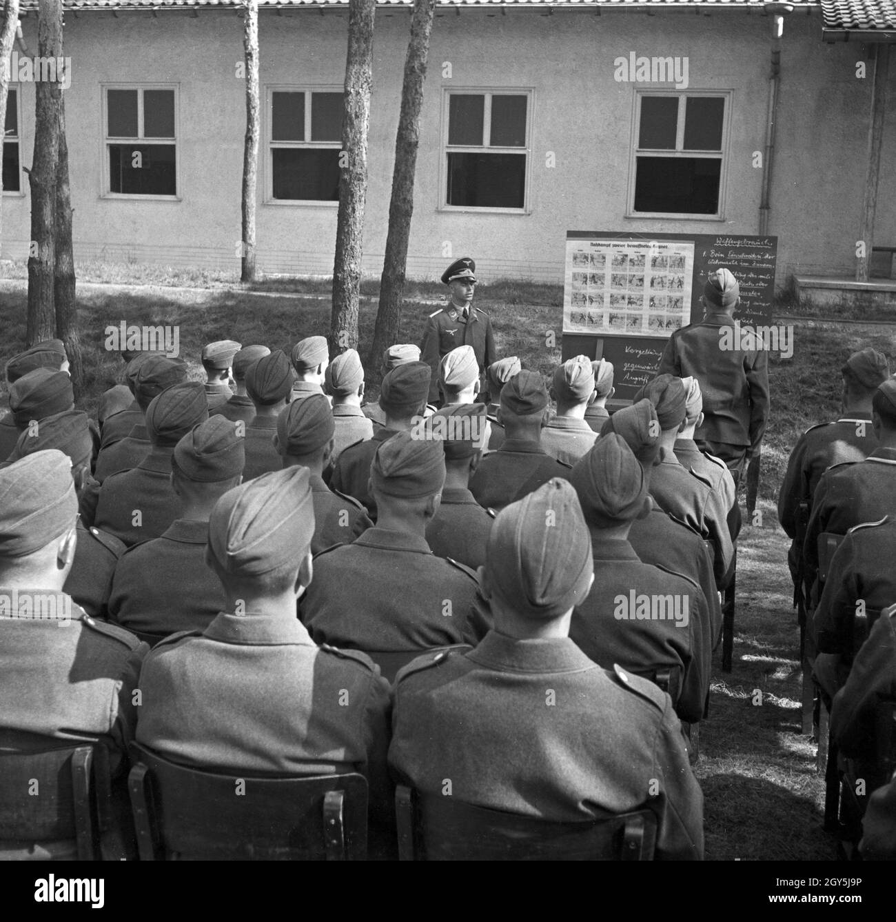 Original-Bildunterschrift: Unterricht im Freien. Besser kann es sich der Soldat kaum wünschen, Deutschland 1940er Jahre. Open air lesson - soldier's wish comes true, Germany 1940s. Stock Photo