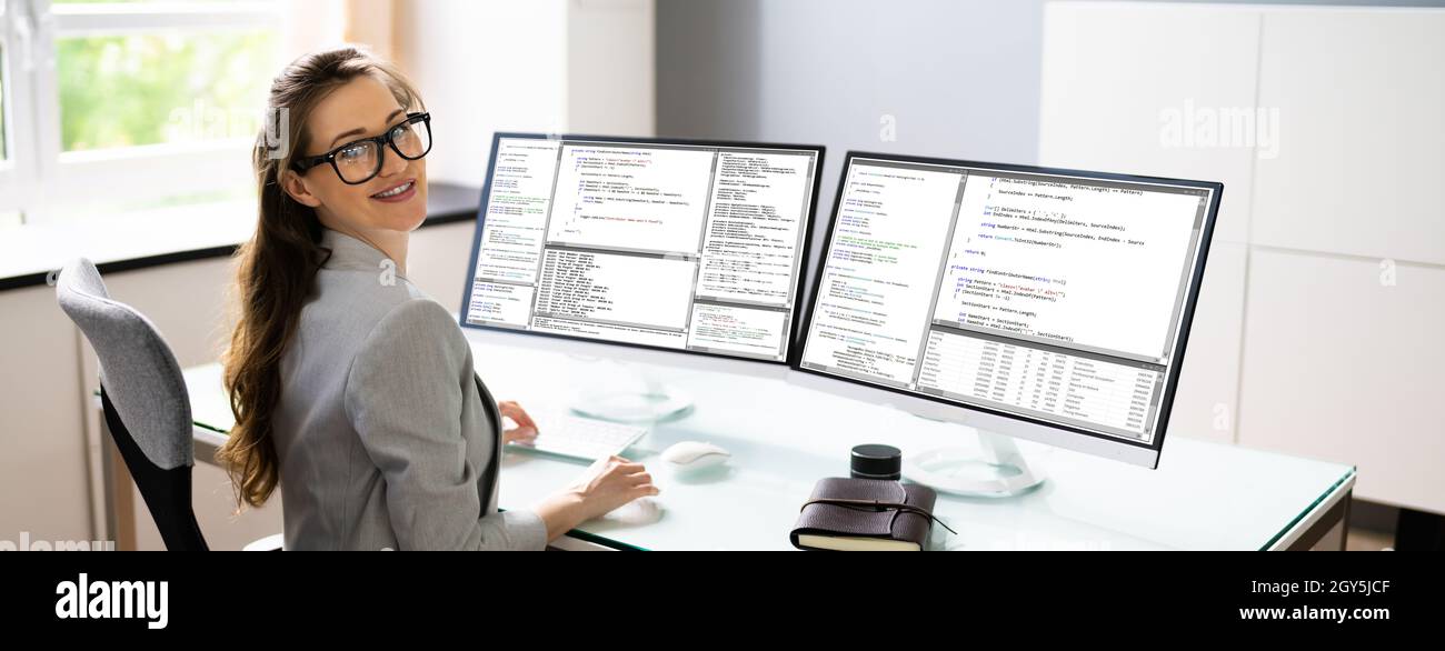 Programmer Woman Coding On Multiple Computer Screens Stock Photo - Alamy