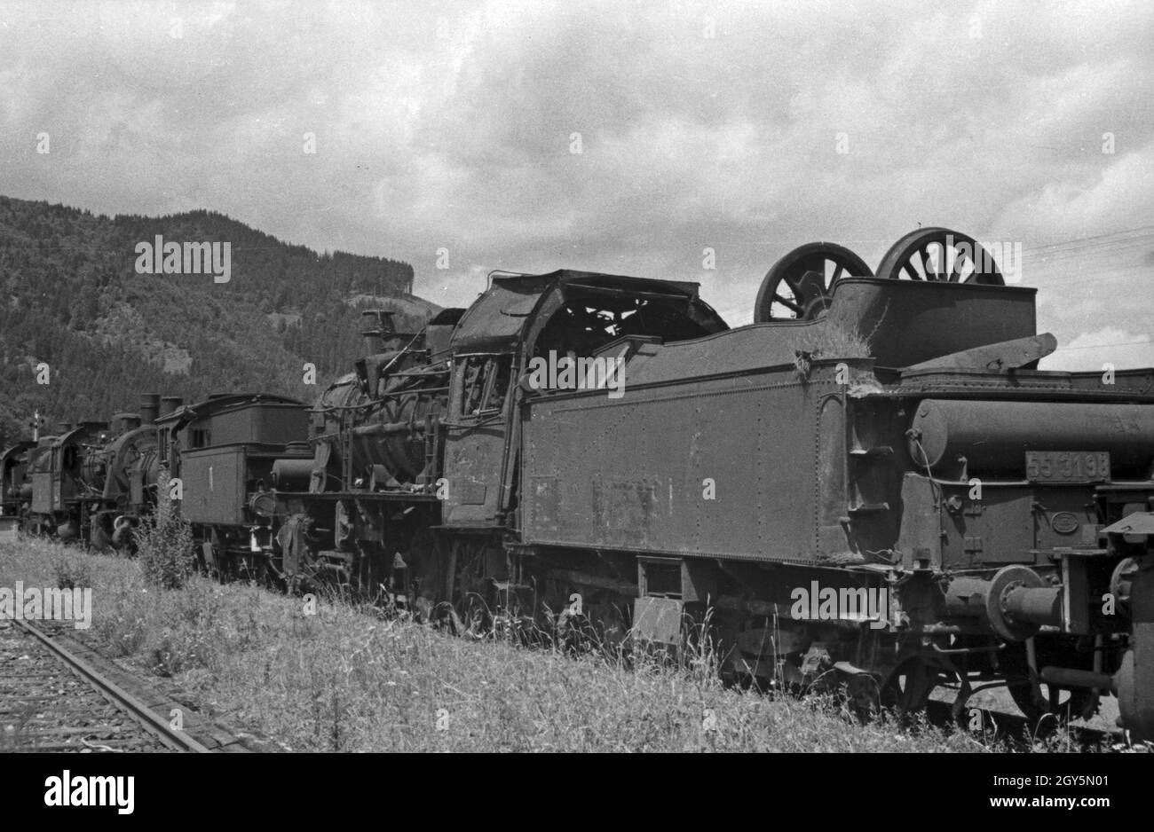 Kriegszerstörte und ausrangierte Dampflokomotiven auf einem Lokfriedhof, Deutschland 1940er Jahre. Steam locomotives, destroyed by war, waiting to be repaired, Germany 1940s. Stock Photo