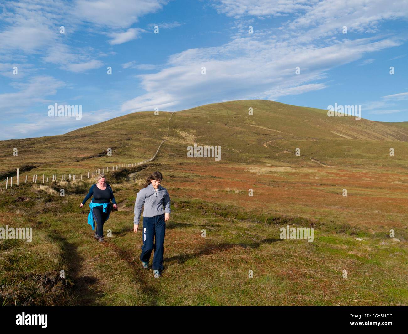 Woman and girl walking highest hill on Orkney Mainland Stock Photo