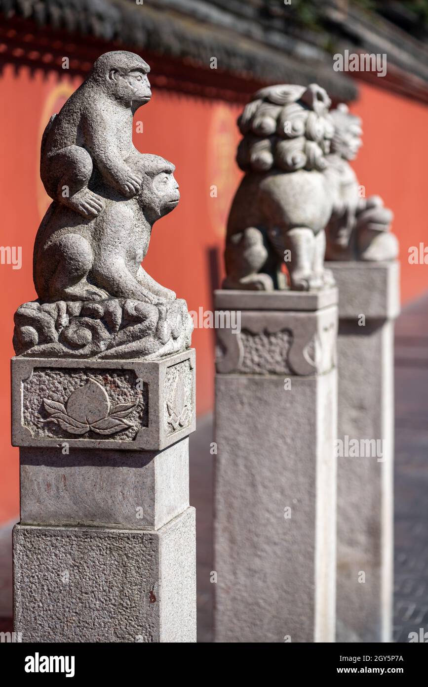Chengdu, Sichuan province, China - Sept 28, 2021 : Three statues in front of the red surrounding wall of Wenshu buddhist monastery. Stock Photo