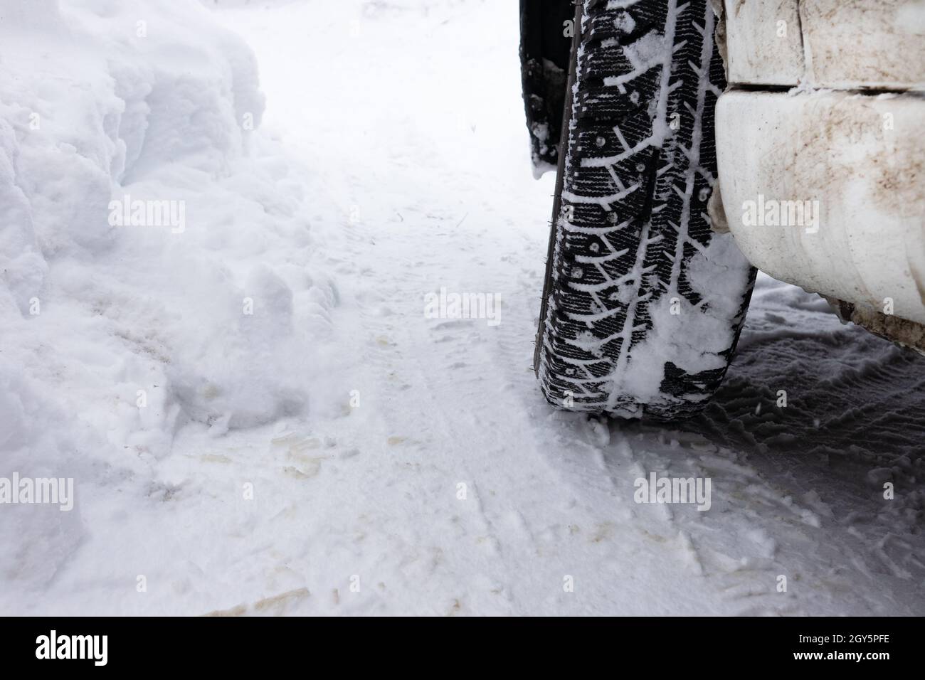 Closeup winter tire. Car tires on the road covered with snow. Stock Photo