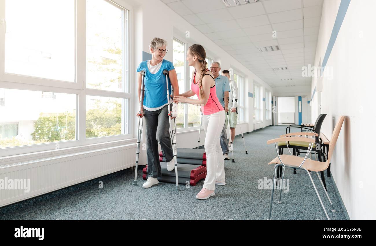 Seniors in rehabilitation learning how to walk with crutches after