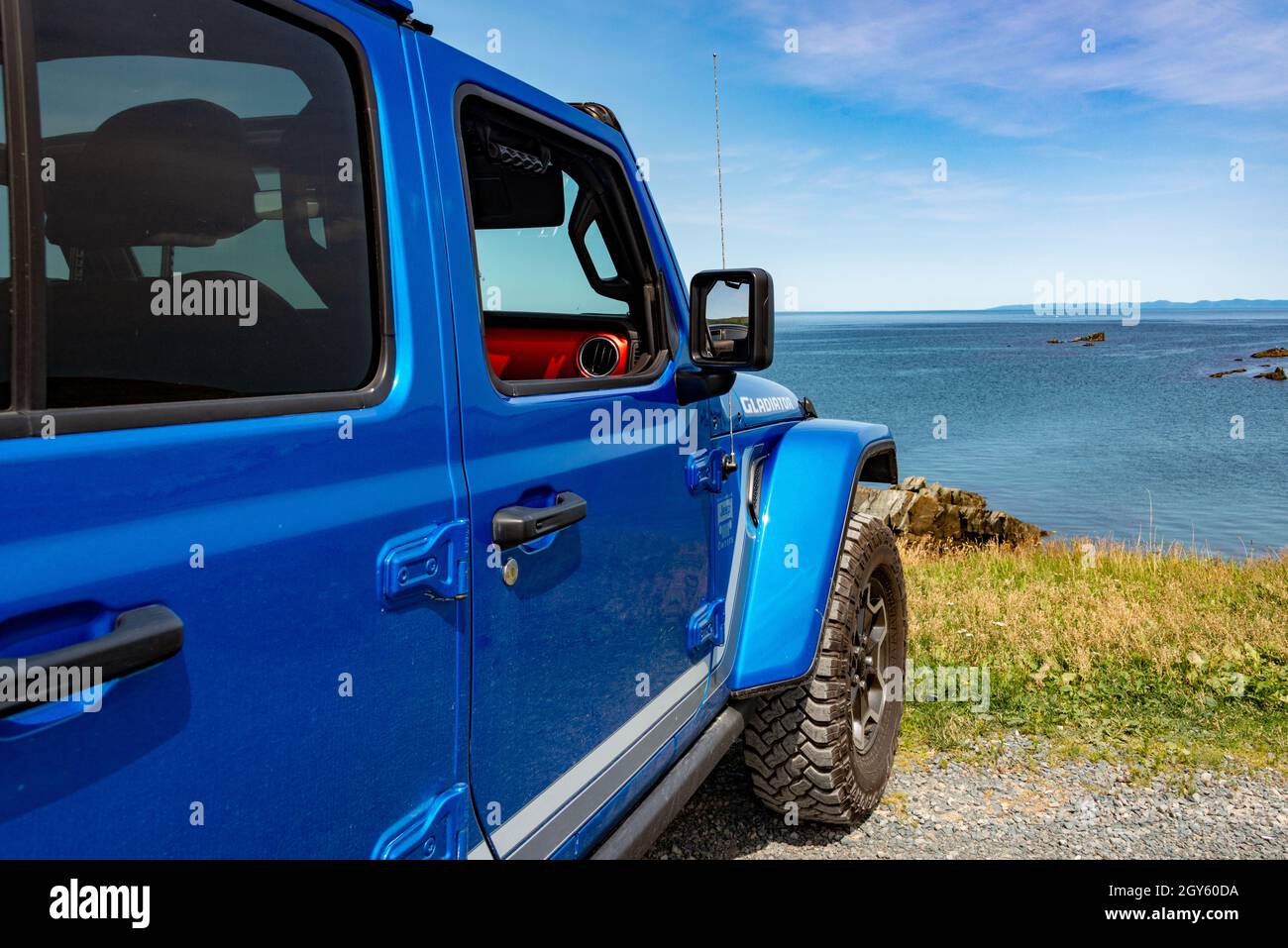 A vibrant blue Jeep Gladiator Rubicon truck 4x4 off road and parked on