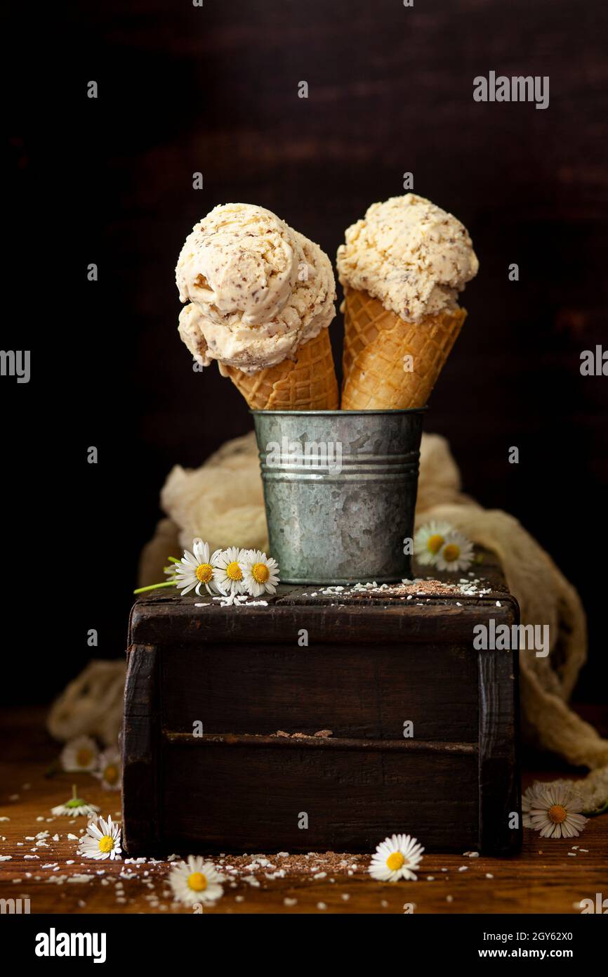 Two waffling cones holding scoops of coconut ice cream. Stock Photo