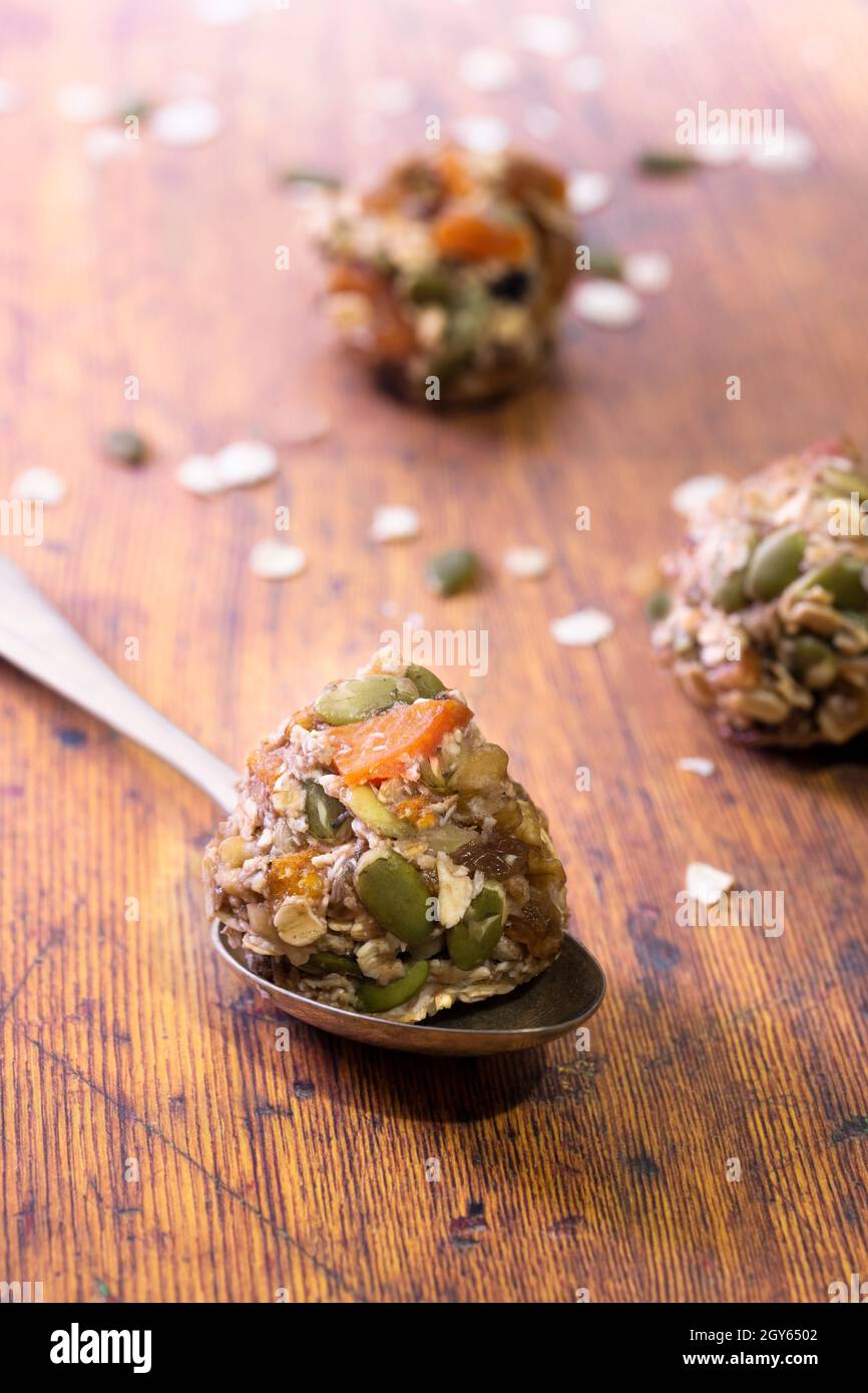 Healthy banana muesli cookie mixture rolled into balls with one on a spoon. Stock Photo