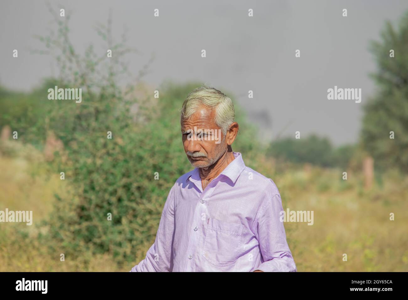 Close-up portrait of an senior aged farmer old man walking in wild ...