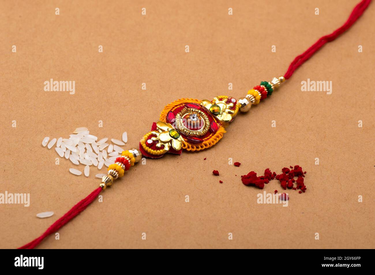 Raksha Bandhan background with an elegant Rakhi, Rice Grains and Kumkum ...