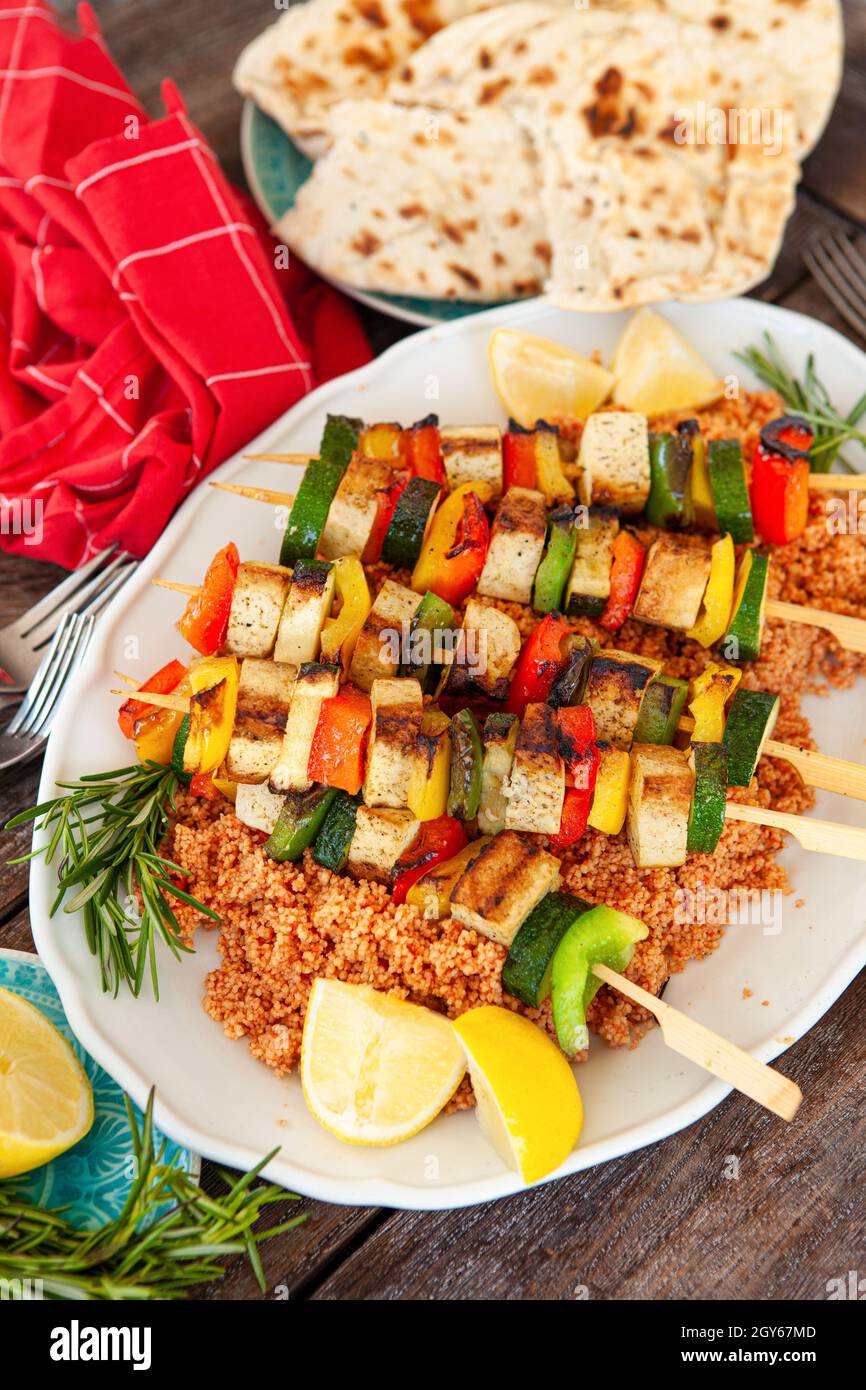 Grilled vegetable skewers with soy on tomato couscous Stock Photo