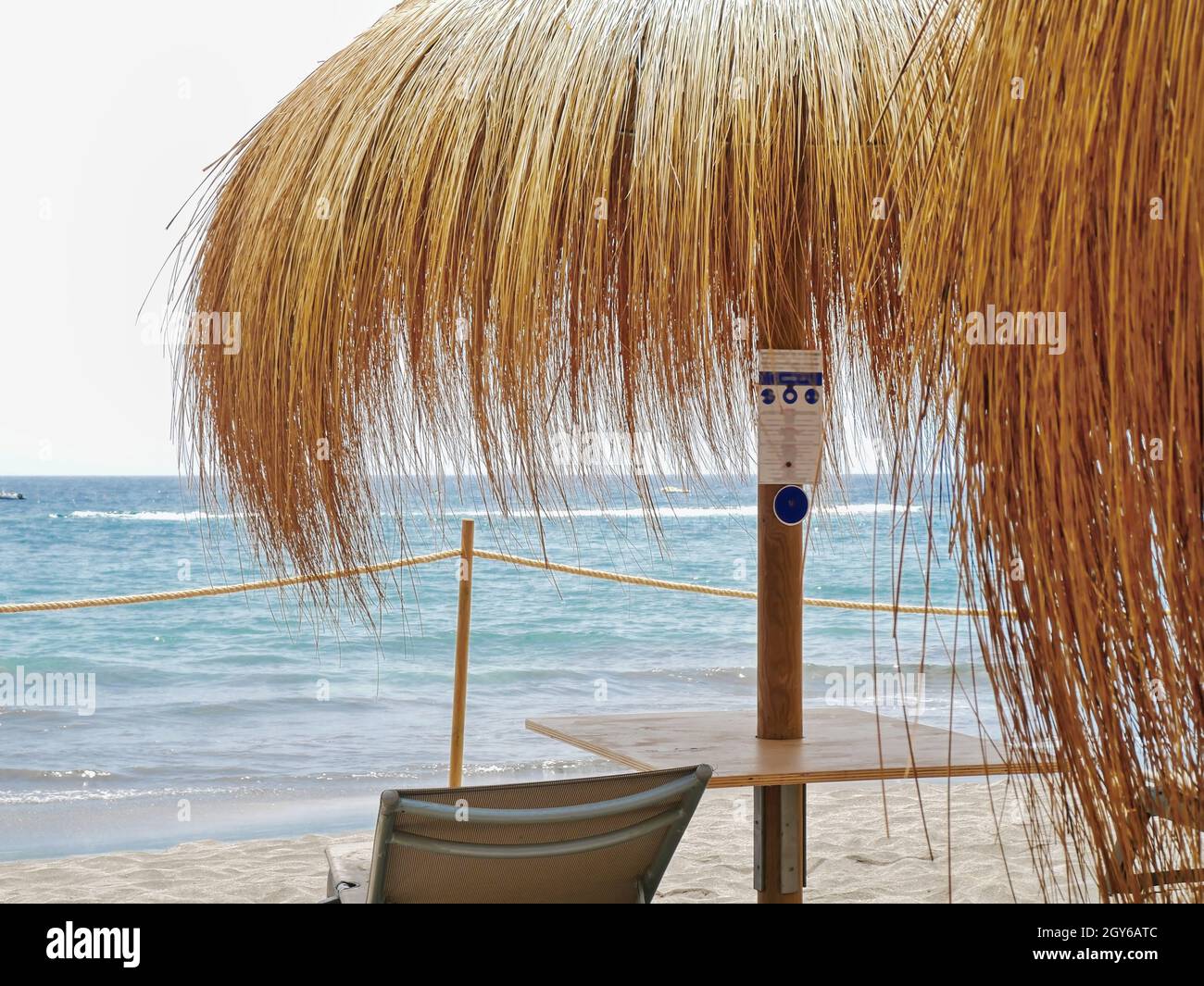 Meditterraner chill out place under a parasol made of bast, right on the  water's edge of the Atlantic in the sand in Tenerife south in Adeje. A  chillo Stock Photo - Alamy