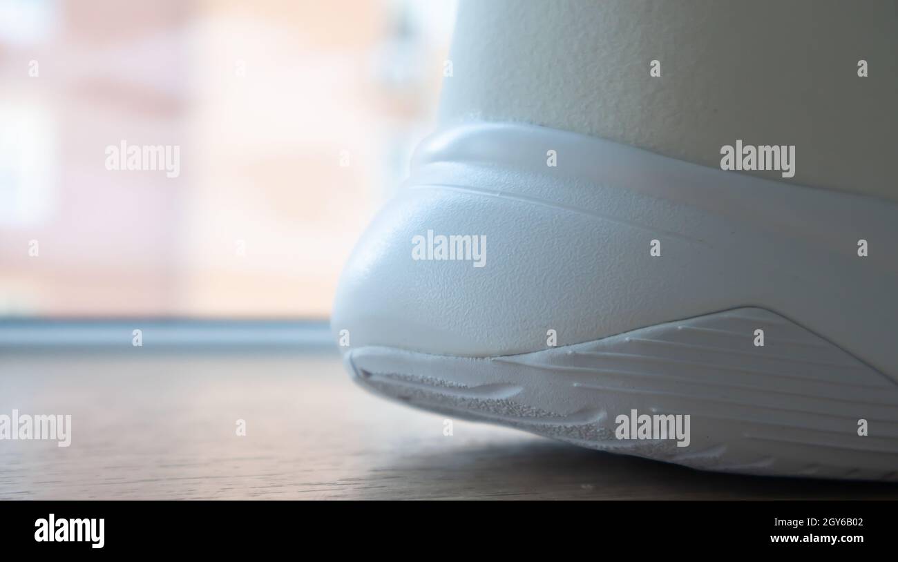 Low angle view of the outsole of the back of new white sneakers. Rubber sole on the heel of men's shoes. Sole for sports and walking shoes. Material t Stock Photo