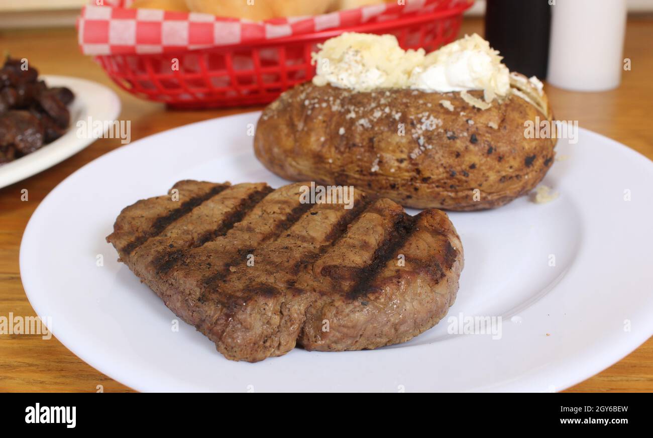 Sirloin Steak With Baked Potato and fresh rolls Stock Photo Alamy