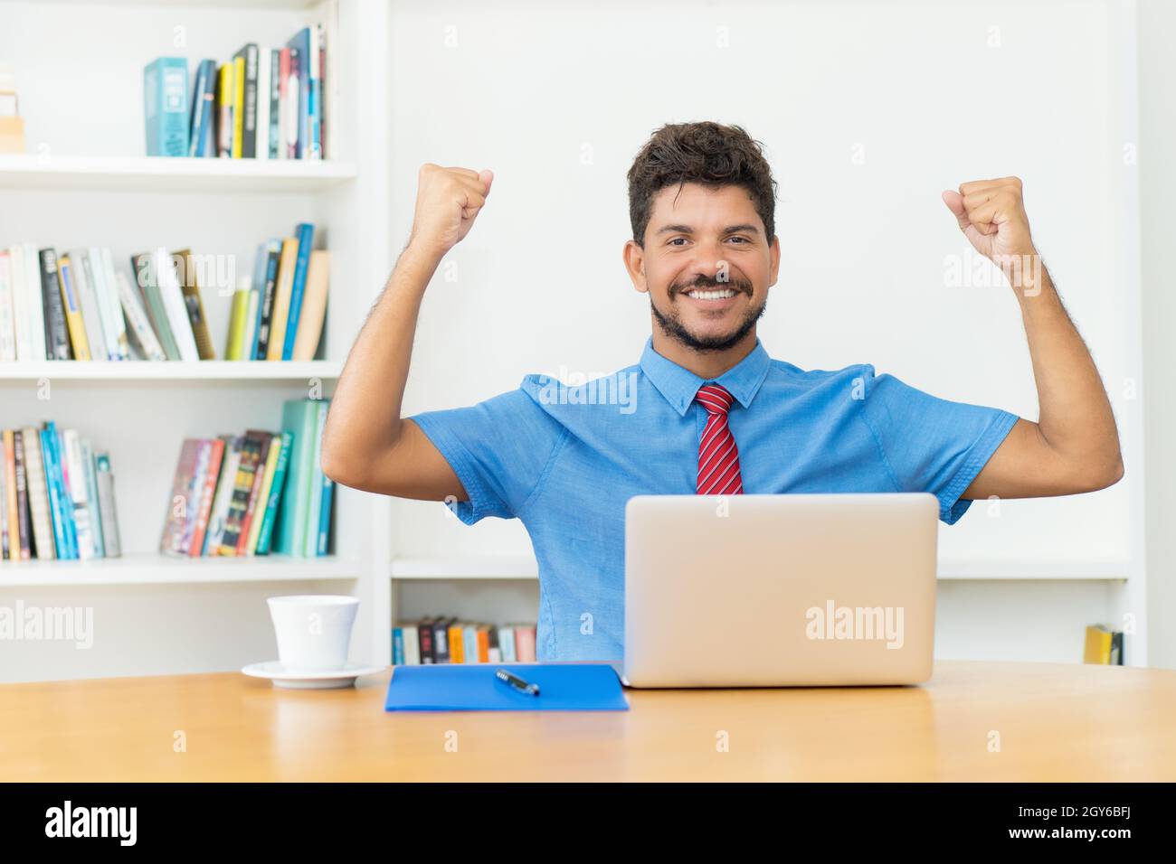 Successfull hispanic male trader at computer at office Stock Photo