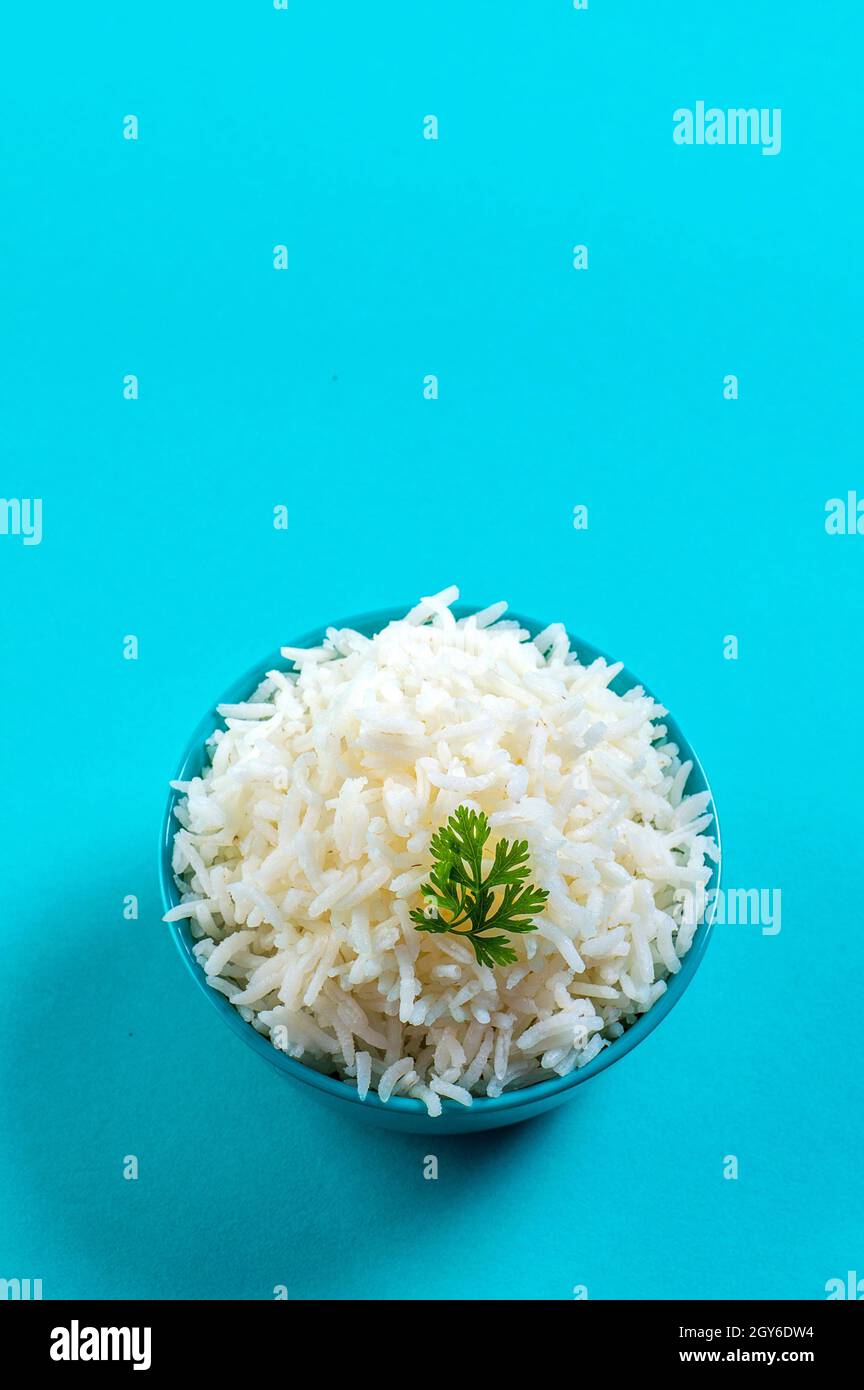 Cooked plain white basmati rice with corriander in a blue bowl on blue