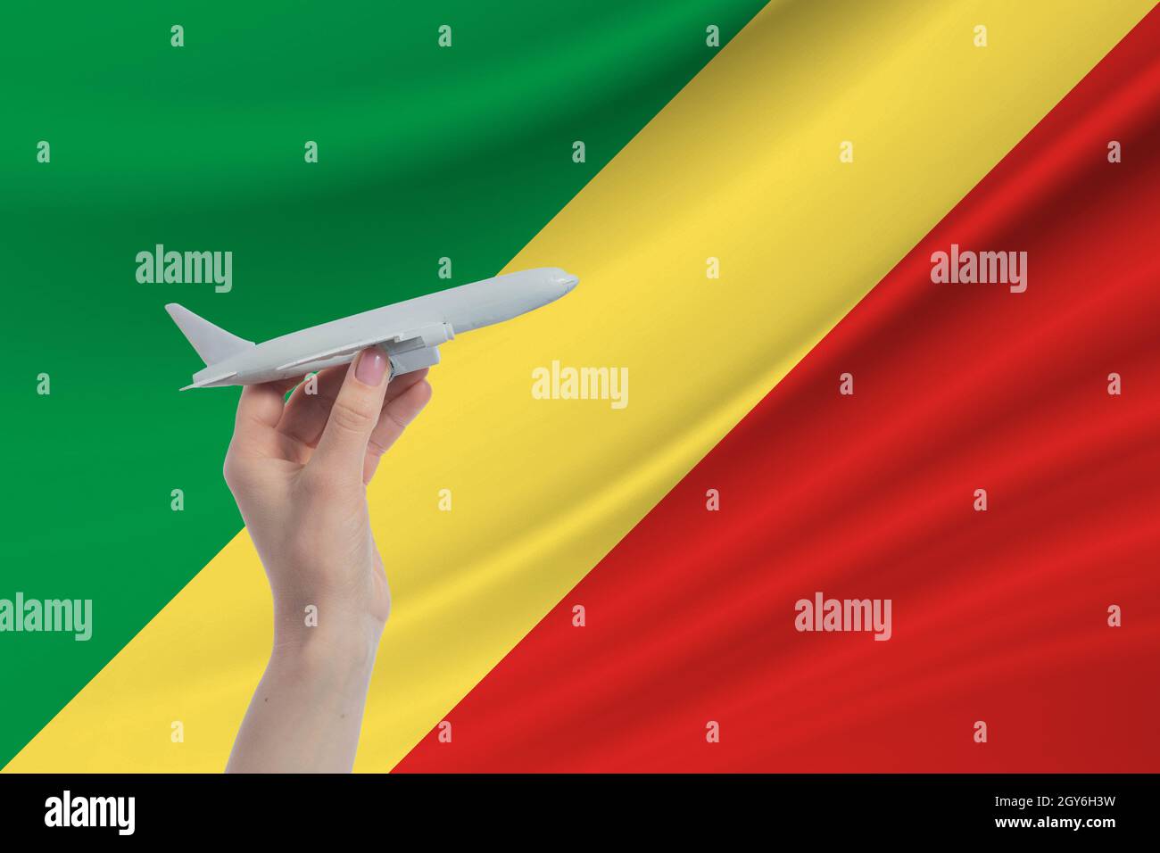 Airplane in hand with national flag of Republic of the Congo Travel to Republic of the Congo. Stock Photo