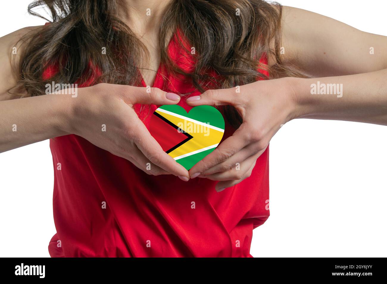 Love Guyana. The woman holds a heart in the form of the flag of Guyana on her chest. Concept of patriotism. Stock Photo