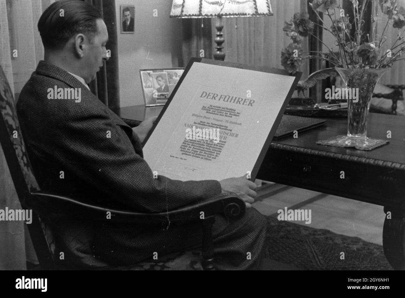 Der Inhaber des Musterbetriebs Wilhelm Plum mit seiner Urkunde, Deutsches Reich 1941. Owner of the model plant Wilhelm Plum with his certificate, Germany 1941. Stock Photo