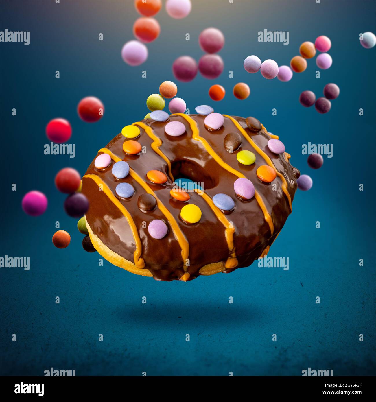 Flying delicious donut with firecracker on blue background Stock Photo