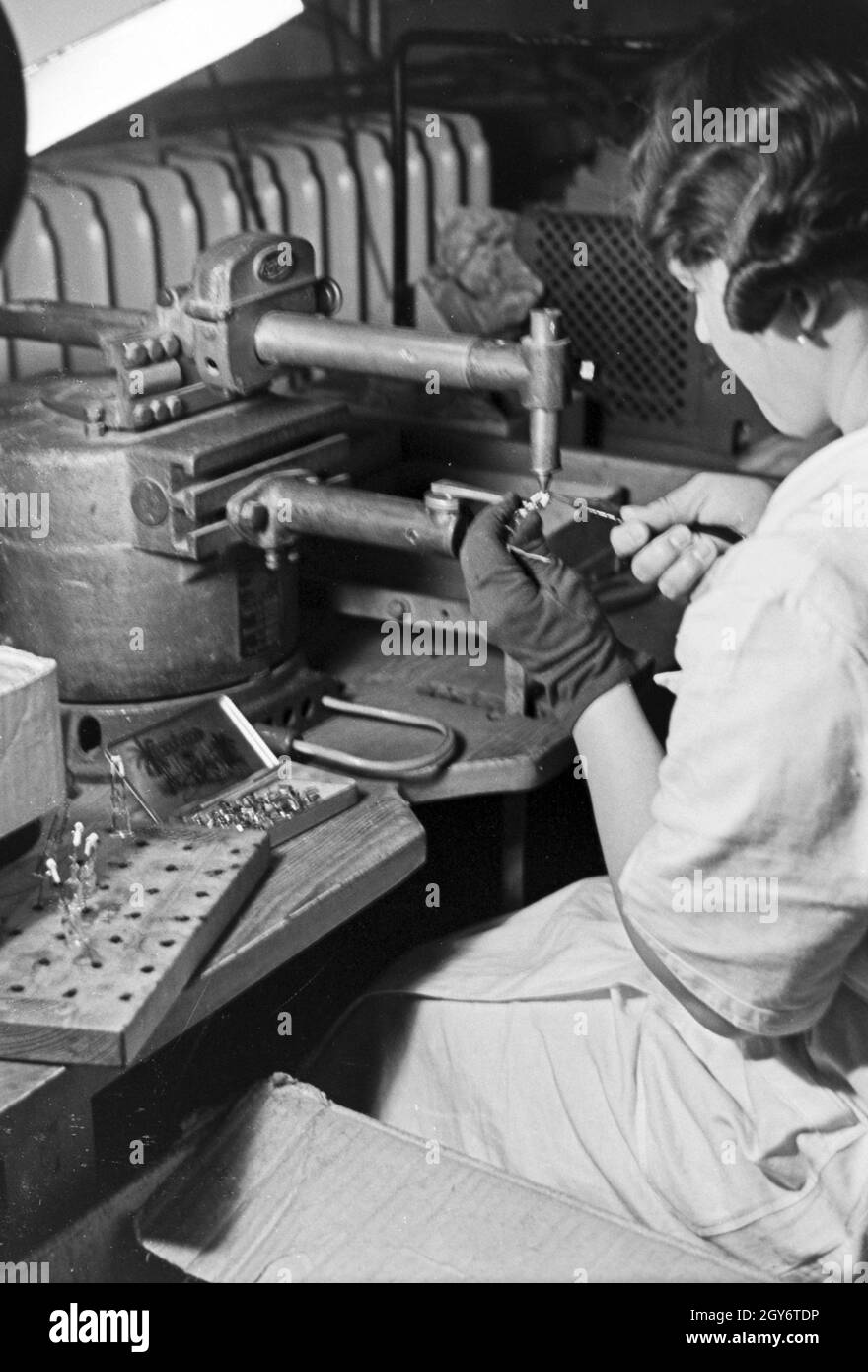 Elektrische Kontakte werden für die Leuchtröhrenherstellung vorbereitet, Deutschland 1930er Jahre. Electric contactors are prepared for the production of fluorescent tubes, Germany 1930s. Stock Photo