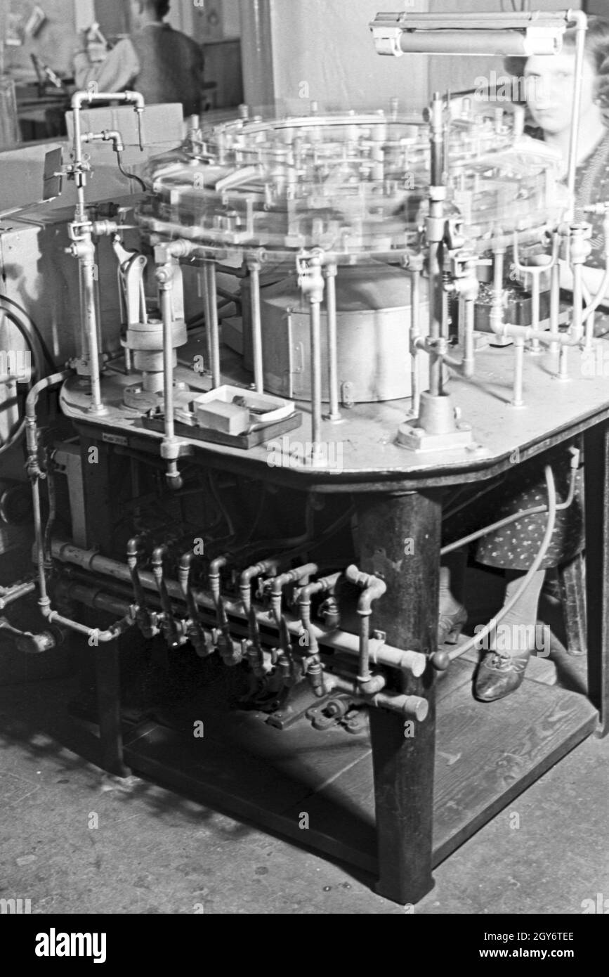 Eine Mitarbeiterin bei der Produktion von Leuchtröhren, Deutschland 1930er Jahre. A female staff memmber producing fluorescent tubes, Germany 1930s. Stock Photo