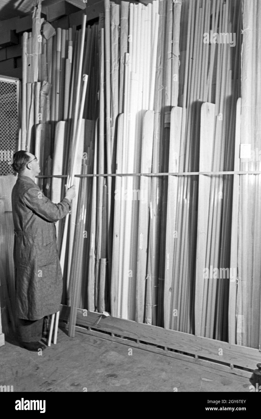Der Lagerist mit fertigen Leuchtröhren, Deutschland 1930er Jahre. Warehouse cleark with completed fluorescent tubes, Germany 10930s. Stock Photo