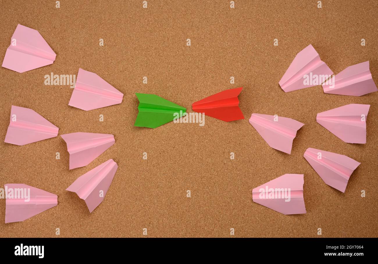 two large groups of paper airplanes on a brown background. Conflict of interest, quarrel and confrontation concept Stock Photo